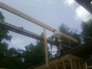 Carpenter setting a ridge beam over a new addition frame — Ice Dam Removal by Roofing Brothers in Sebree